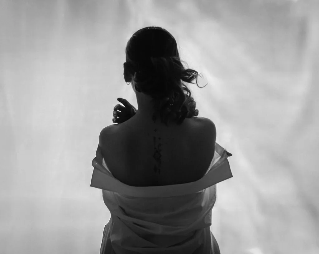 Portrait intimiste – silhouette féminine de dos en séance boudoir
