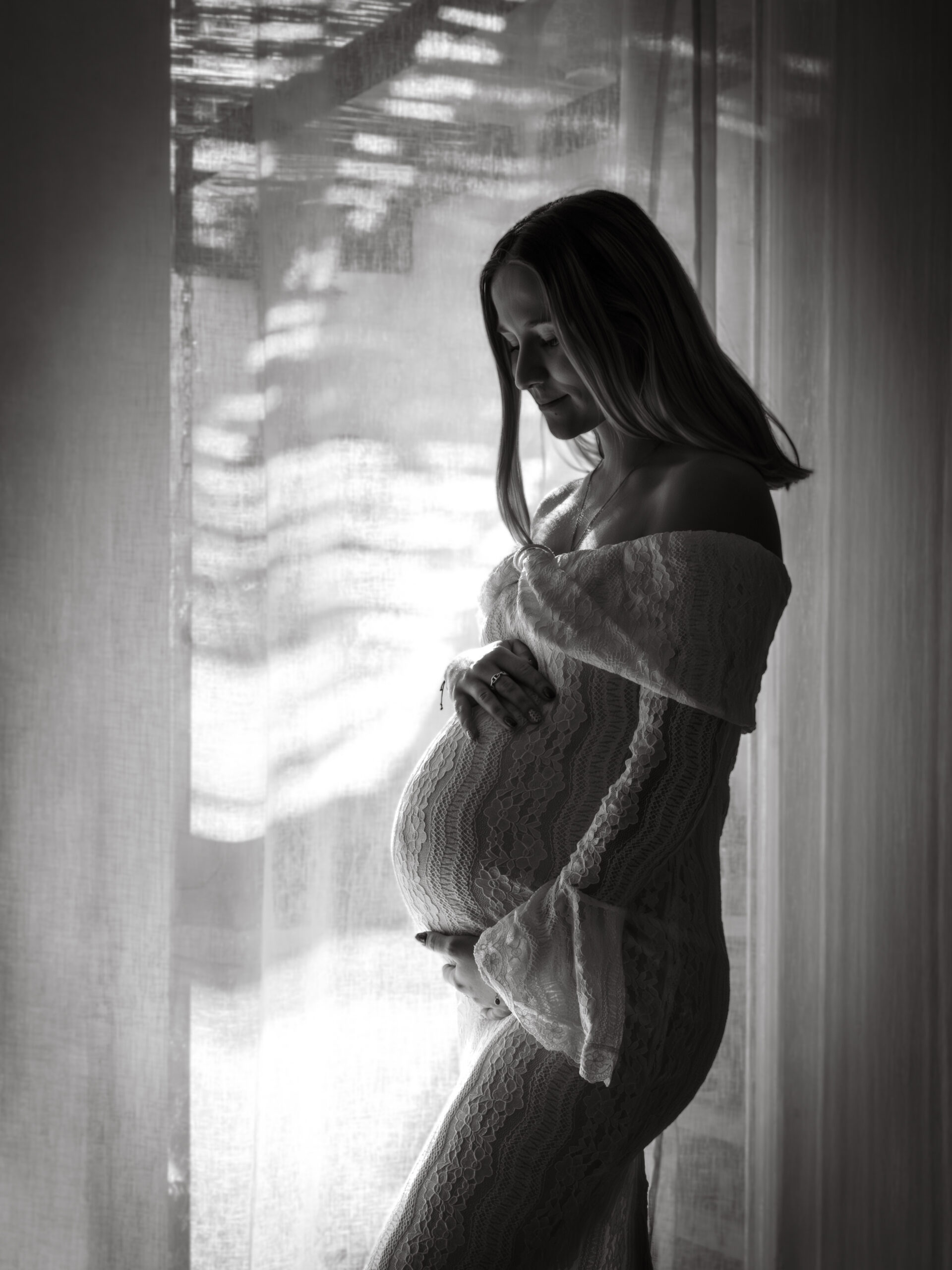 Femme enceinte en robe fluide posant dans un studio photo intérieur à Marseille