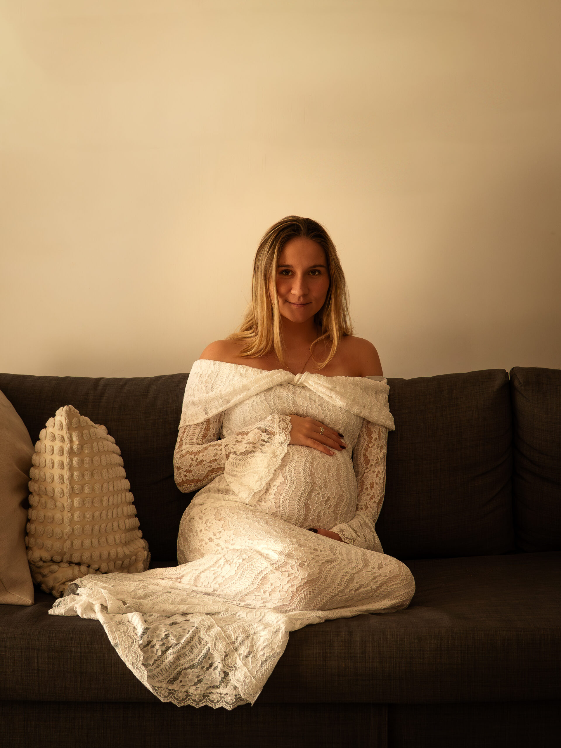 Photo de grossesse en studio avec femme enceinte mettant en valeur son ventre