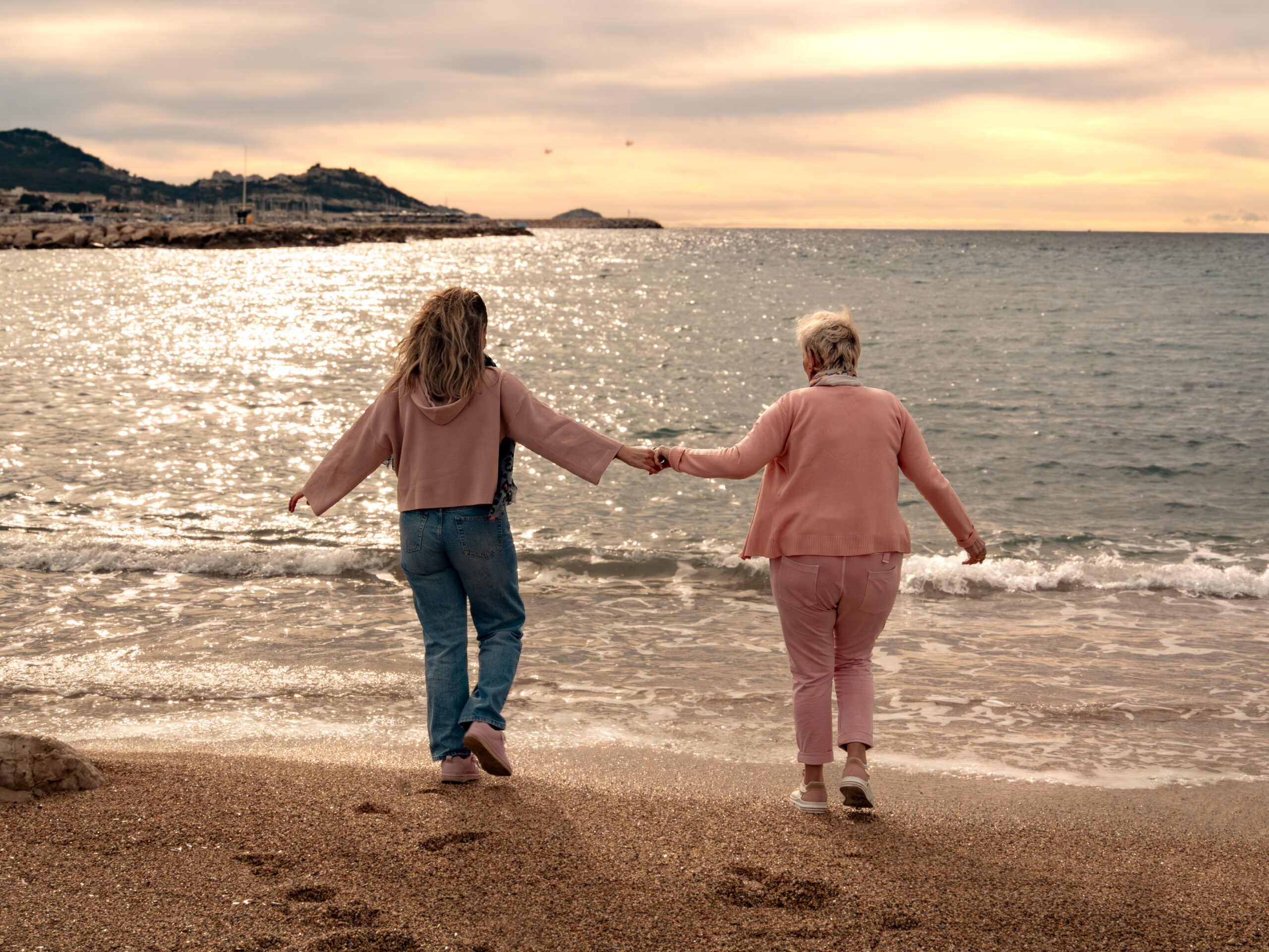 Mère et fille se promenant au bord de la mer au coucher du soleil lors d’un shooting photo à Marseille